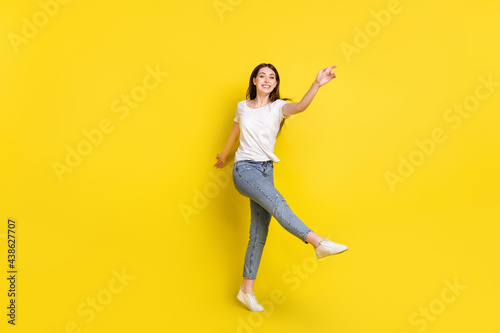 Full length body size photo pretty girl smiling dancing cheerful at party isolated vibrant yellow color background