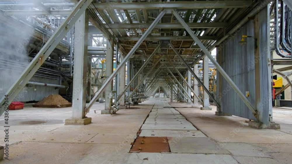 Moving forward under a metal ceiling at an oil refinery. The epic atmosphere of the oil industry. An inside look at getting gasoline Moving forward under a metal ceiling at an oil refinery. The epic atmosphere of the oil industry. An inside look at getting gasoline