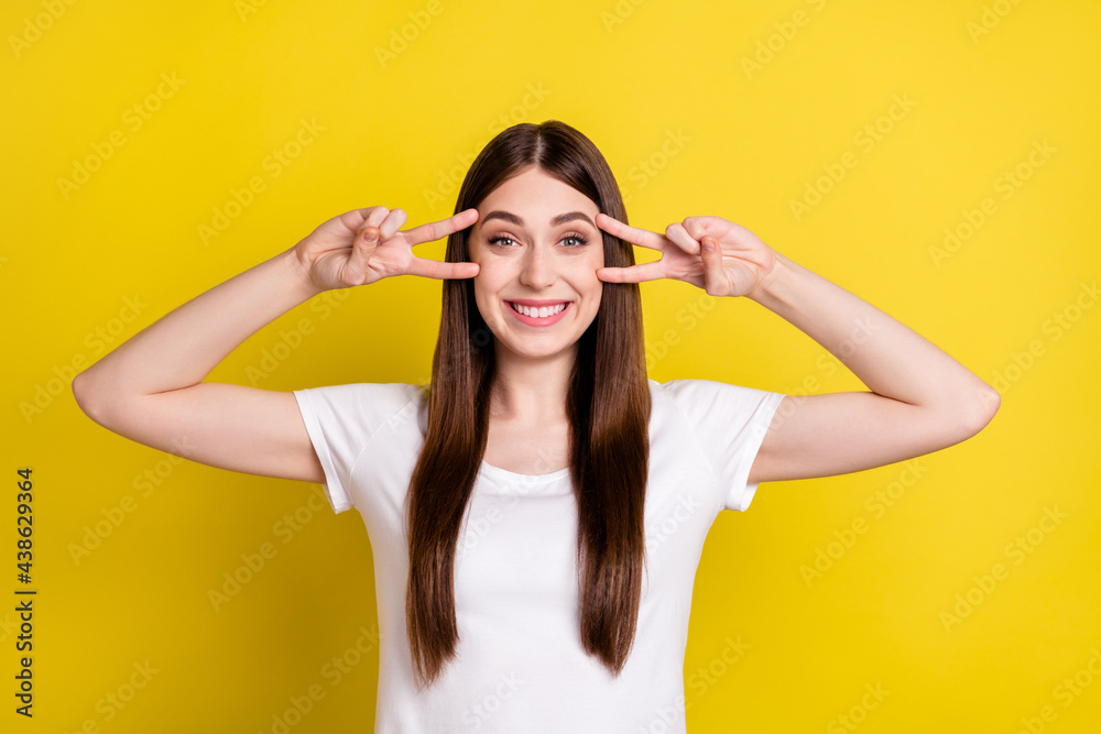 Photo of young cheerful girl happy positive smile show peace cool v-sign have fun isolated over yellow color background