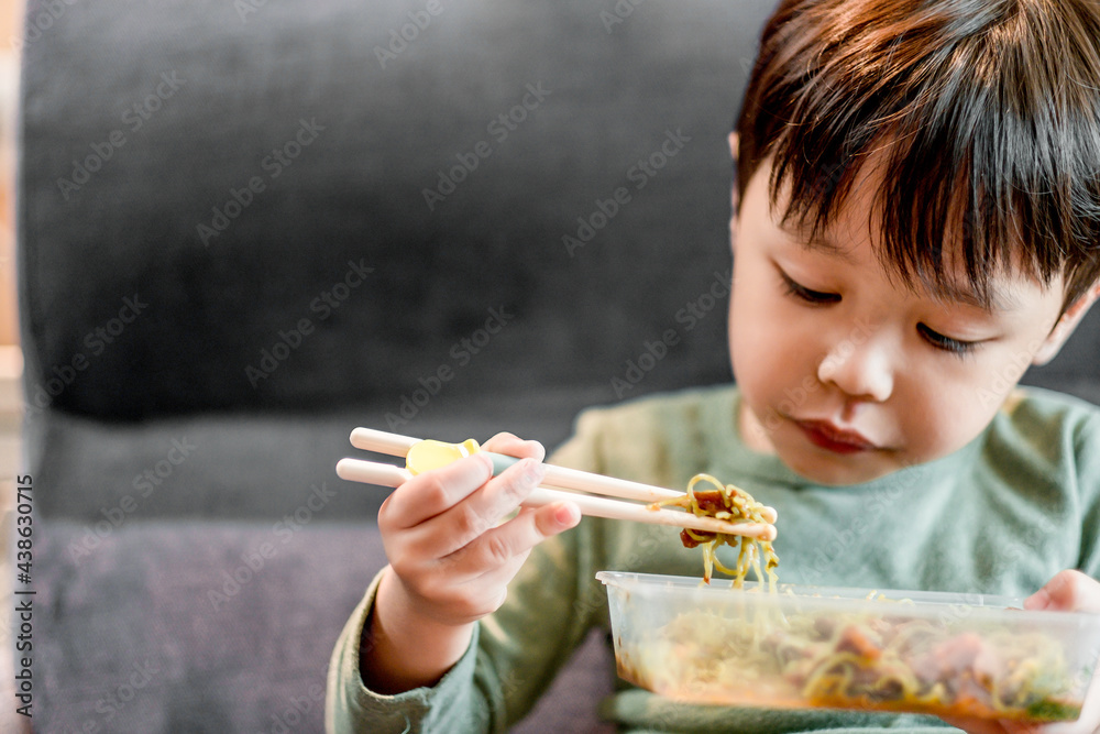 Cute little boy eating delicious Roasted Duck Noodle with chopstick by himself. Young boy is very hungry. Soft focus. Copy space. Cute little boy eating delicious Roasted Duck Noodle with chopstick by himself. Young boy is very hungry. Soft focus. Copy space.
