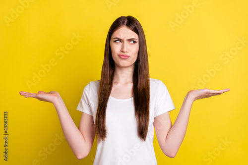Photo of young girl unhappy hesitate hold hands solution decision ad option isolated over yellow color background