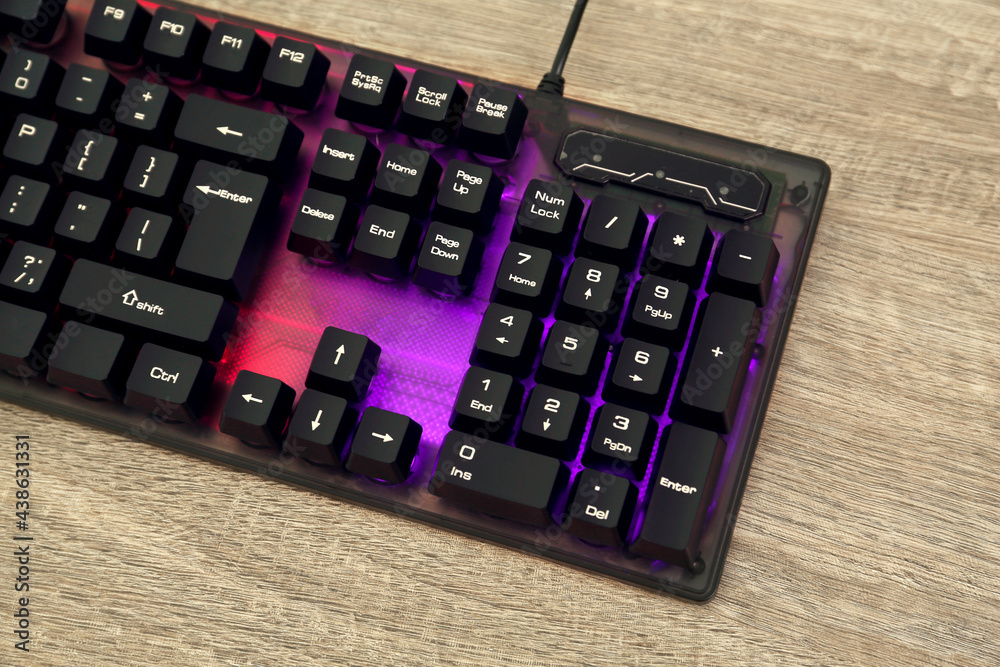 Modern RGB keyboard on wooden table, above view Modern RGB keyboard on wooden table, above view