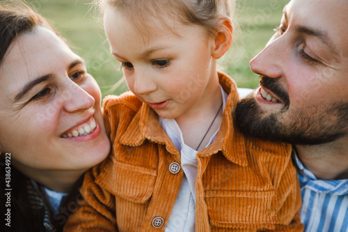 A hipster family walks in a summer field.