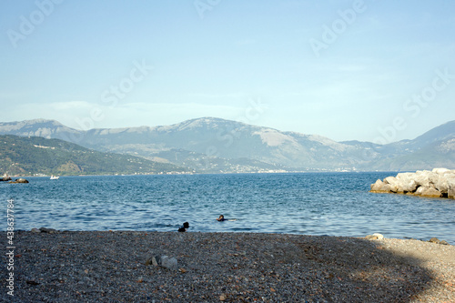 Part of the Policastro gulf seen from the beach of Scario with some boys scuba diving at sunset. Salerno, Italy, Europe. photo