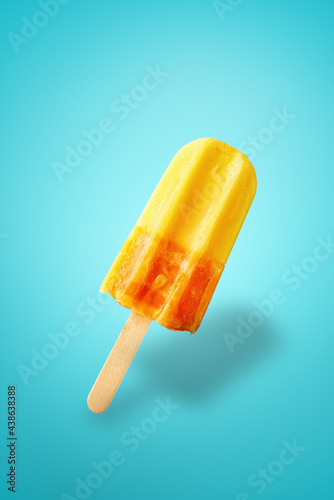 Colorful popsicle ice cream on blue background. Frozen summer ice fruit with shadow, close up. Summer background