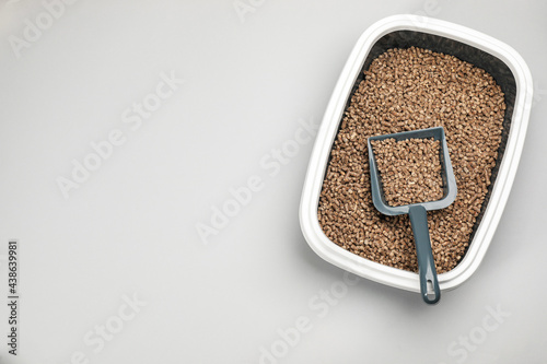 Cat litter tray with filler and scoop on light background, top view. Space for text photo
