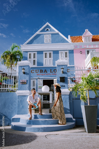 Curacao, Netherlands Antilles View of colorful buildings of downtown Willemstad Curacao Colorful restored colonial buildings in Pietermaai, couple men and woman mid age posing by colorful buildings photo