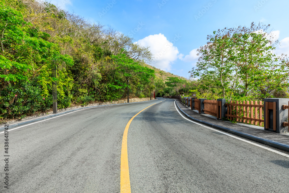 Empty asphalt road and mountain scenery on sunny day.