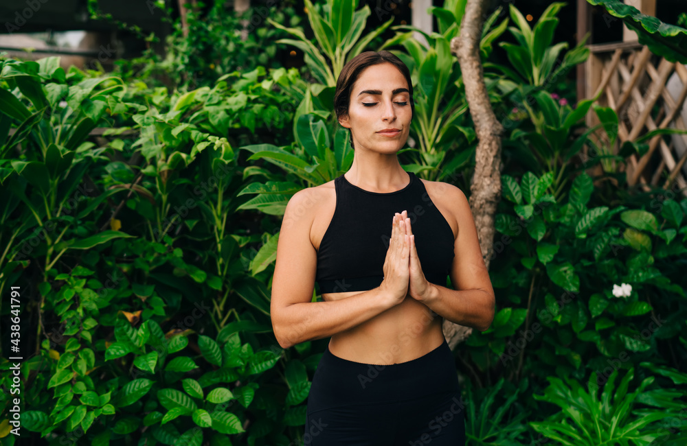 Beautiful female yogi in black sportswear practice hatha during morning meditation on nature, attractive woman in namaste pose getting inner peace and feel soul harmony keeping healthy lifestyle Beautiful female yogi in black sportswear practice hatha during morning meditation on nature, attractive woman in namaste pose getting inner peace and feel soul harmony keeping healthy lifestyle