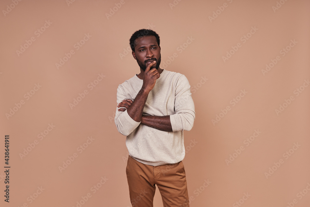 Thoughtful young African man in casual clothing looking away Thoughtful young African man in casual clothing looking away