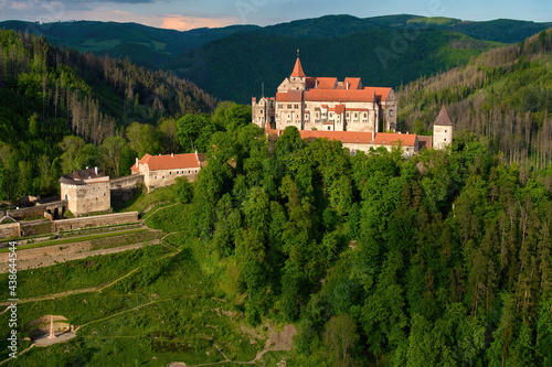 Ancient royal Moravian castle Pernstejn  standing on a hill covered green forest against partly cloudy blue sky. Aerial photography.  Bohemian-Moravian Highlands  Czech landscape  travel point.