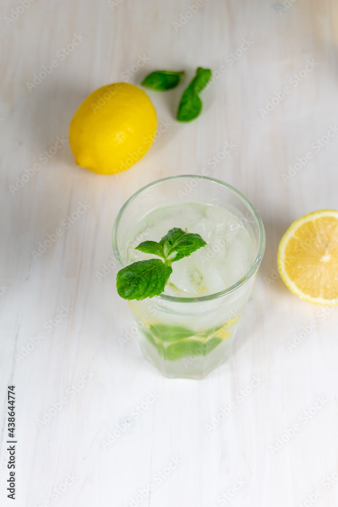 glass of cold lemon lemonade with mint and ice on white background glass of cold lemon lemonade with mint and ice on white background