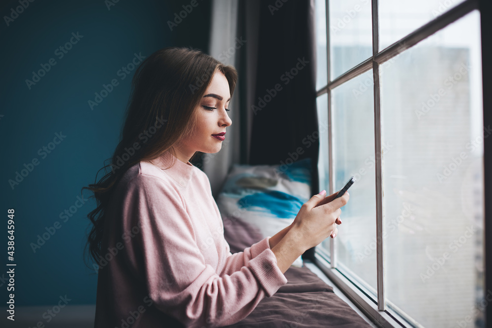 Smiling woman typing message on mobile phone Smiling woman typing message on mobile phone