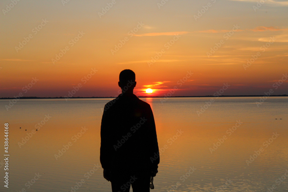 A man watches a sunset on the North Sea A man watches a sunset on the North Sea