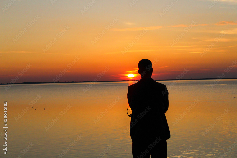 Fototapeta premium A man watches a sunset on the North Sea