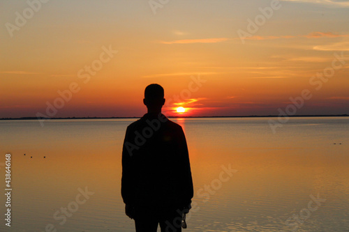 A man watches a sunset on the North Sea © PeSchne