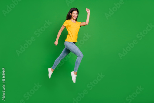 Full length body size view of nice attractive cheerful girl jumping striving isolated over bright green color background