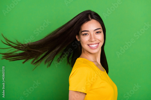 Profile side photo of cheerful nice happy young woman smile good mood fly hair isolated on green color background photo