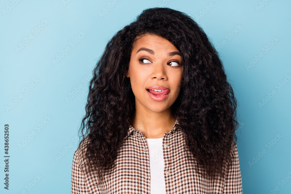 Photo of flirty wavy hairdo young lady look empty space lick teeth wear brown shirt isolated on vivid blue color background Photo of flirty wavy hairdo young lady look empty space lick teeth wear brown shirt isolated on vivid blue color background