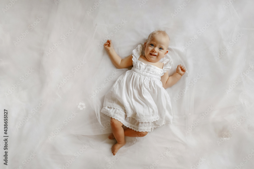 Top view on the adorable female baby lying on the bed. Concept of happy childhood. Top view on the adorable female baby lying on the bed. Concept of happy childhood.