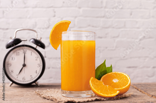 Glass of orange juice with clock.