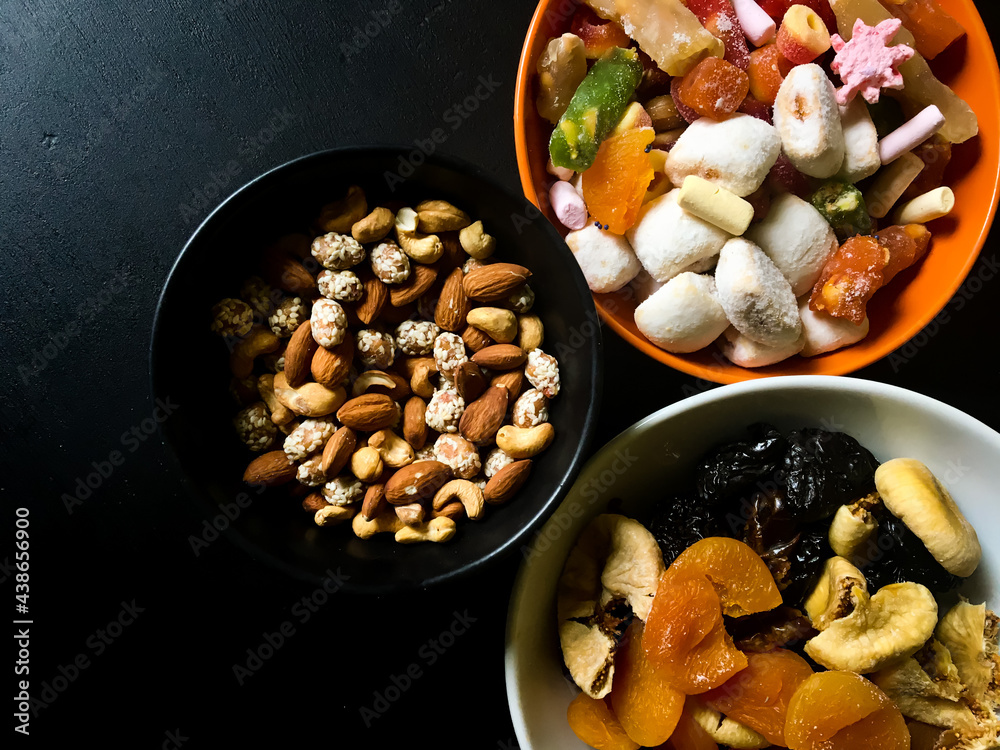Dried fruits and Turkish delight with nuts mix on a black table background. And also its a very healty food