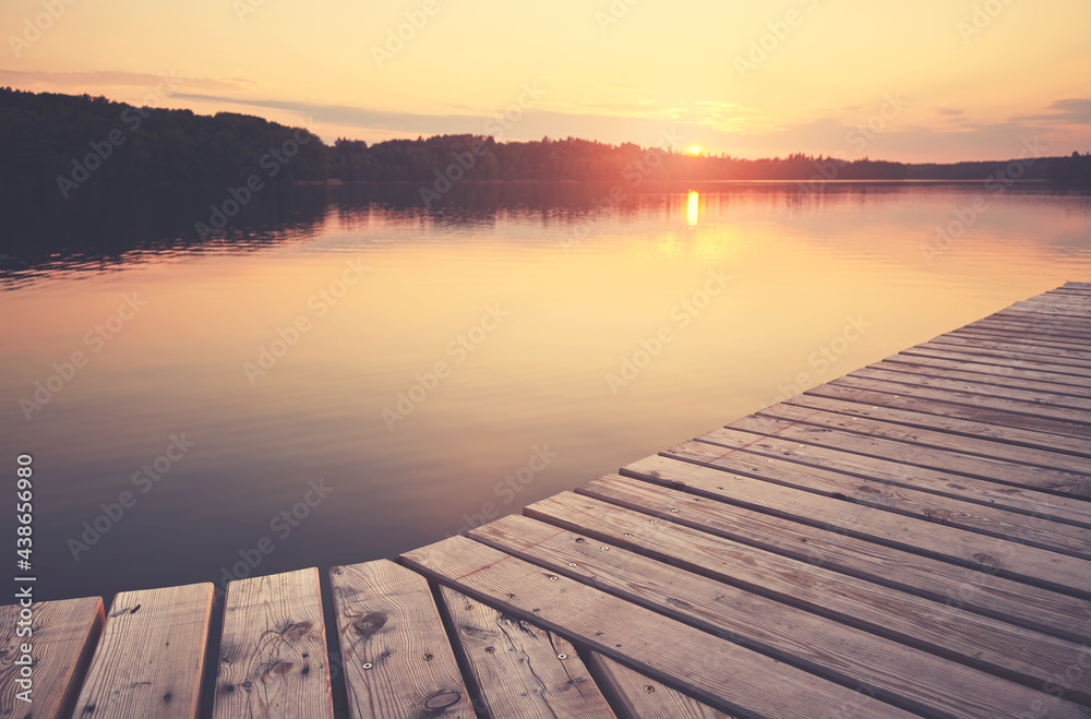 Wooden pier at Lipie Lake at sunset, selective focus, color toning applied, Strzelce Krajenskie, Poland.