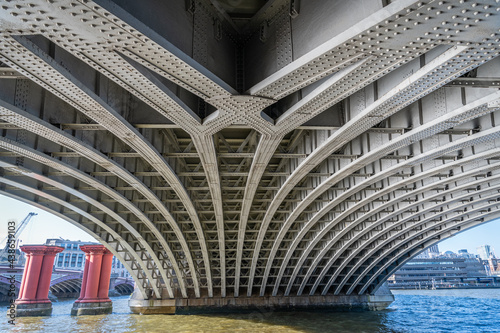 The underside of Blackfriars Railway Bridge over the River Thames  with some of the remaining columns from the old bridge photo