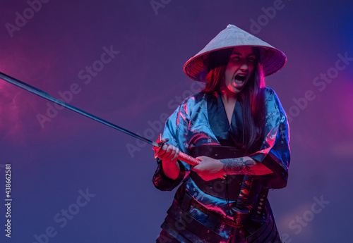 Screaming woman samurai in fight pose with katana