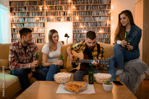 Canvas Print Friends on a house party playing guitar and drinking beer