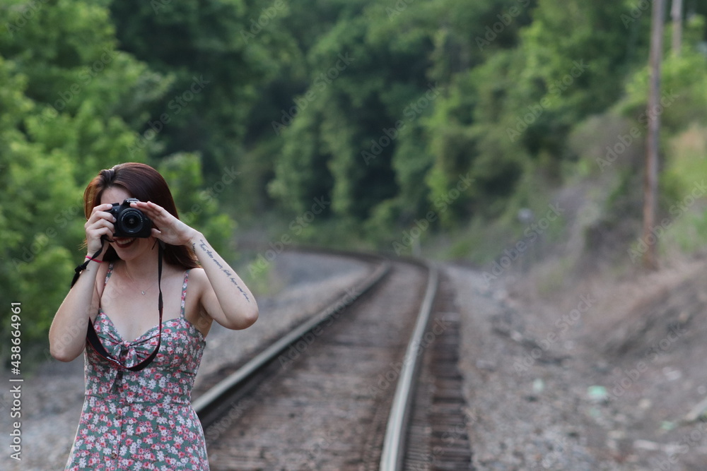 beautiful woman with train tracks and camera