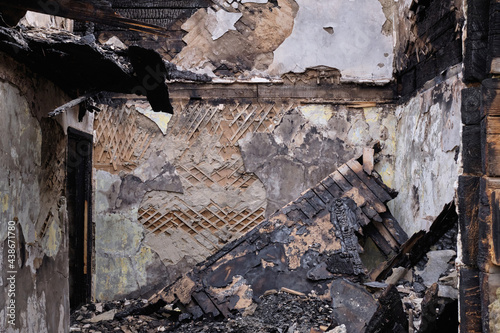 Burned and ruined house interior after fire, consequences of fire disaster accident. Wall after a strong fire in the house. Ruined house building after a fire