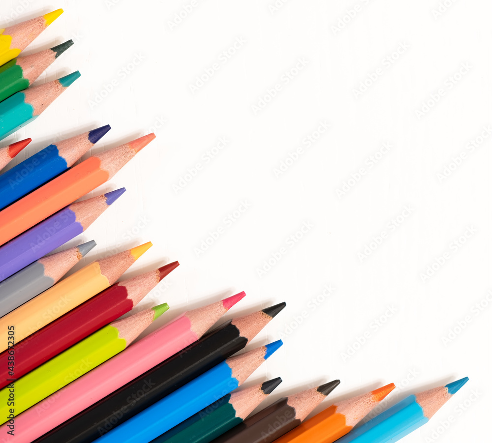 Fototapeta premium Color pencils on white background, top right view with space for text. Back to school concept copy space for text