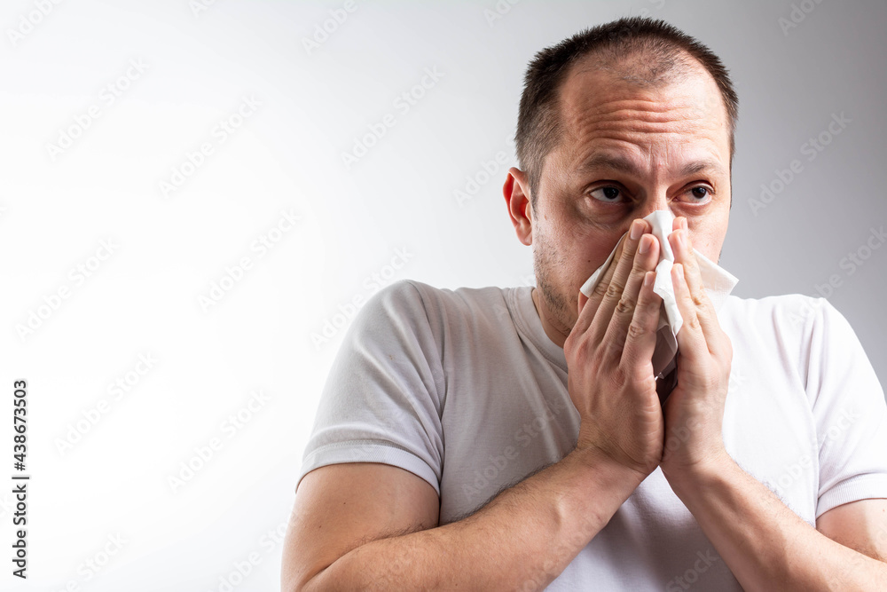 studio picture from a middle aged man with handkerchief. Sick guy isolated has runny nose. man makes a cure for the common cold.