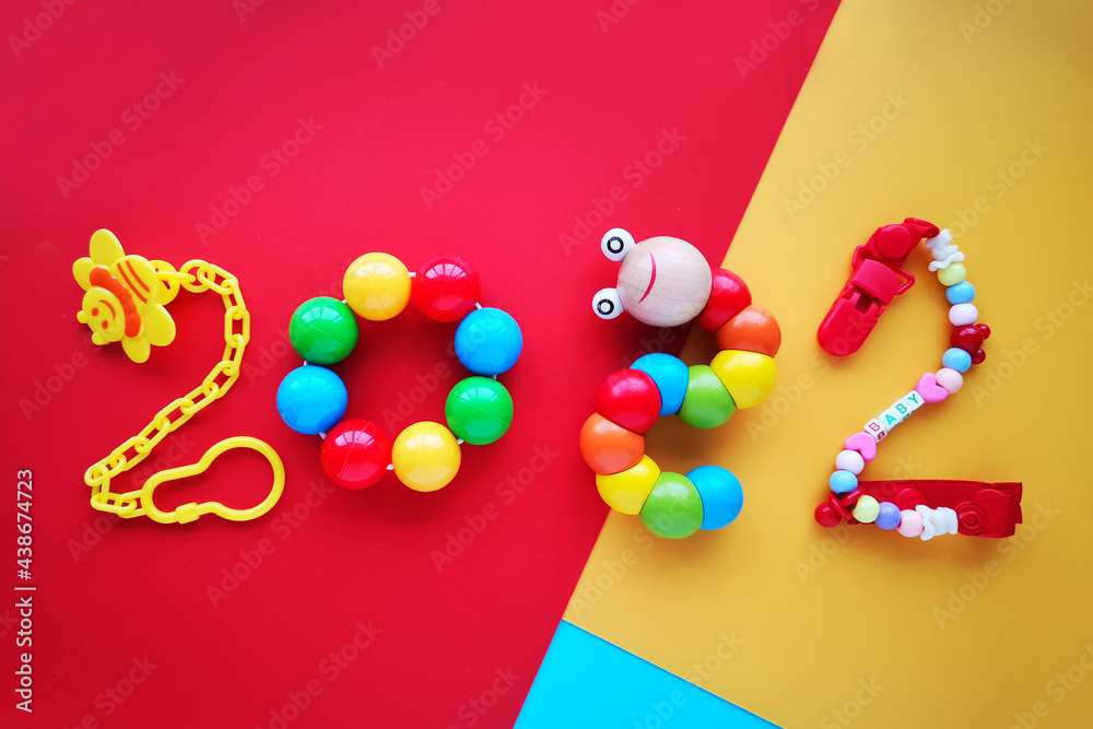 Year 2022, number lined with childrens toys on paper colored background. Elements - rattles, holders, educational games.Christmas calendar theme for articles about children in the holiday Year 2022, number lined with childrens toys on paper colored background. Elements - rattles, holders, educational games.Christmas calendar theme for articles about children in the holiday