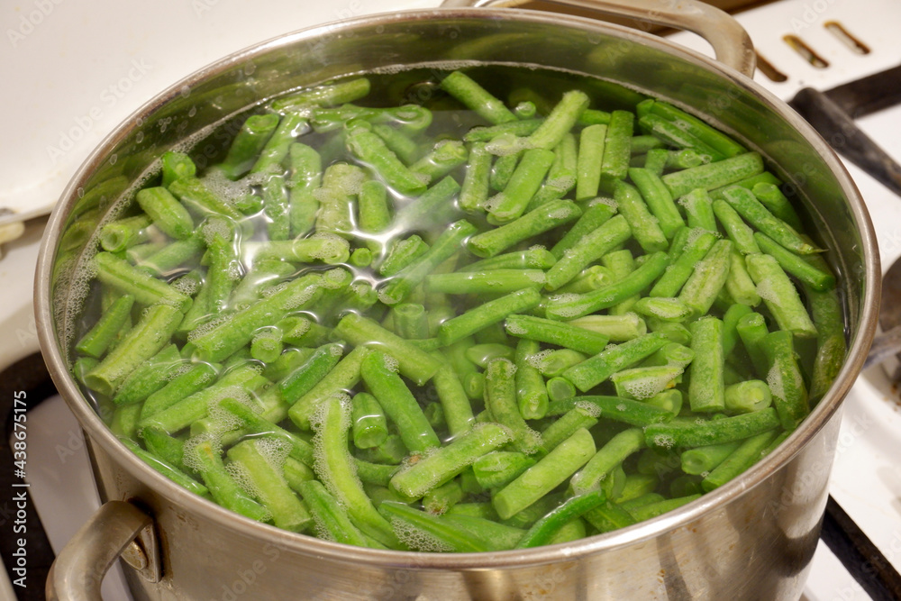 Green beans are cooked in an iron saucepan Green beans are cooked in an iron saucepan