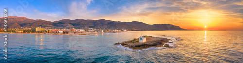 Fotografie An old white church in a small island at sunset in Malia, Crete, Greece