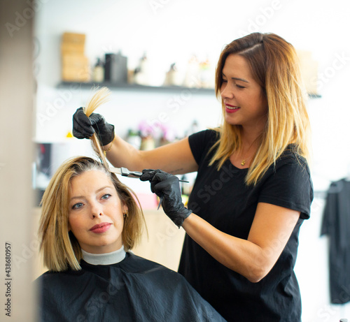 Female hairdresser staining hair of female customer