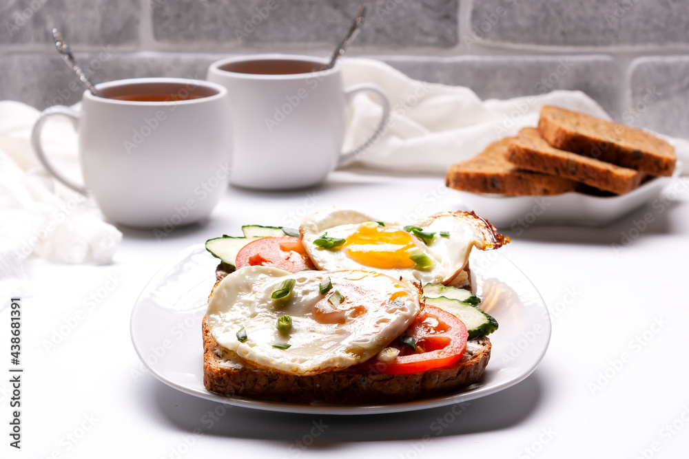 Sandwiches with egg, tomatoes, cucumbers, a plate of bread, two cups of tea. Sandwiches with egg, tomatoes, cucumbers, a plate of bread, two cups of tea.