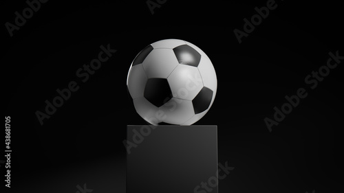 Black and White Football on a plinth against a Black Background. photo