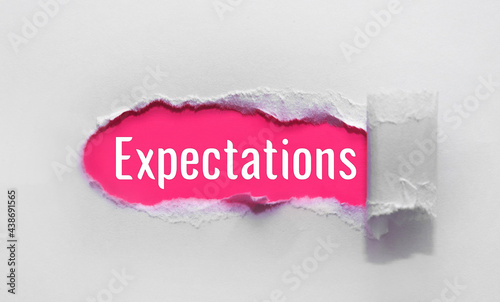 inscription Expectations word on blue torn papper