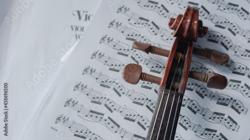 Close up detail on violin body, bow and music notes background. Classic instrument with copy space area 