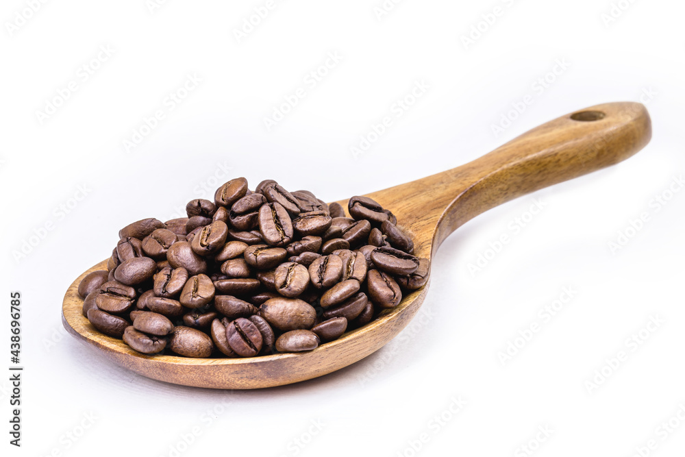 Obraz premium Brazil coffee seeds in rustic wooden spoon, on isolated background with copy space