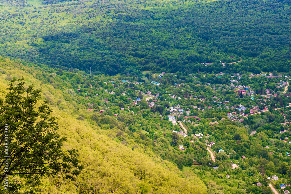 View from the mountain to the village in green summer vegetation