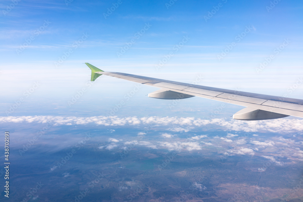 View from the airplane window at a beautiful blue sunrise and the airplane wing above the clouds. View from the airplane window at a beautiful blue sunrise and the airplane wing above the clouds.