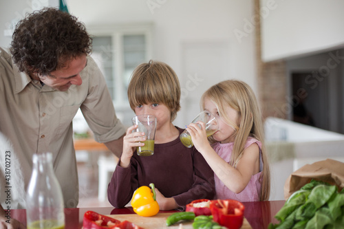 Family preparing a healthy beverage in the kitchen at mediterranean home.
 photo