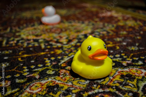 Fotografie Yellow toy duck on an old carpet.