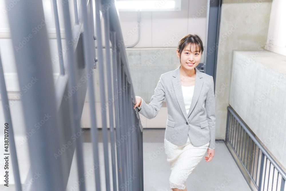 オフィス内を歩く若いビジネスウーマン オフィス内を歩く若いビジネスウーマン