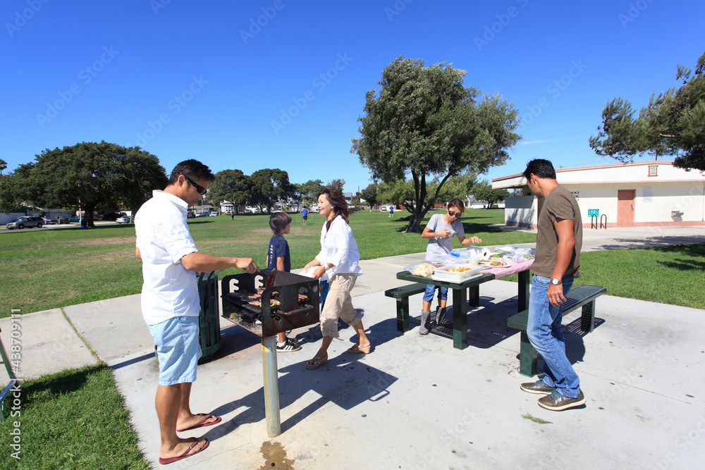 Two families enjoying BBQ in the park Two families enjoying BBQ in the park