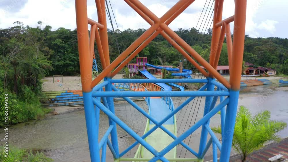 Looking between the colorful metal posts of a steel pedestrian bridge painted in red green and blue Looking between the colorful metal posts of a steel pedestrian bridge painted in red green and blue